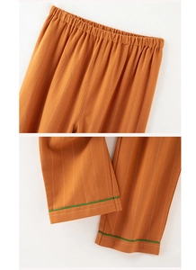 Detail of striped cotton pajama pants with elastic waist and green hem contrast trim