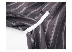Close-up of reinforced seam and white piping on striped cotton pajama fabric detail