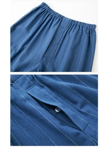 Detail view of blue striped cotton pajamas trousers with elastic waist and button fly