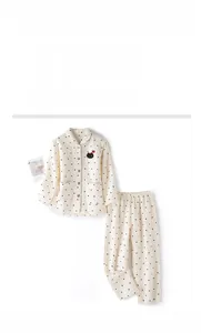 Detail of quilted air cotton pajamas featuring cute cat embroidery and black polka dots