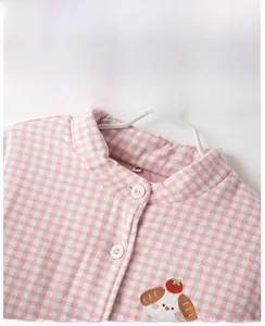 Close-up of pink plaid quilted pajama top featuring soft flannel texture and dog embroidery