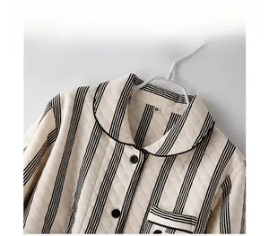 Detailed view of beige quilted pajama set featuring black trim collar and vertical stripes