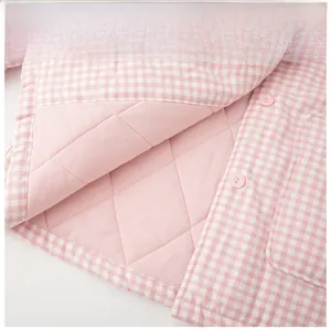 Detail of pink plaid quilted cotton loungewear featuring windproof hem and snap button