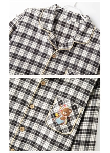 Detail of V-neck plaid cotton pajama top with yellow piping and bear embroidery