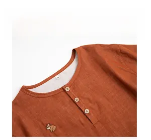 Close-up of caramel cotton pajama top with wooden buttons and French Bulldog embroidery