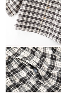 Close-up of black and white plaid cotton pajama fabric with wooden button and fine stitching