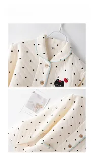 Close-up of quilted children's pajama top with embroidery and polka dot patterns