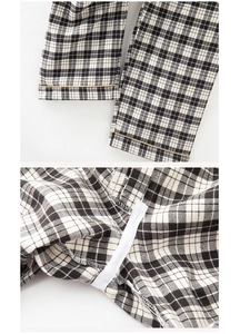Detail view of cotton pajama pants with black and white plaid and yellow stitching