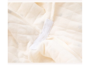 Macro detail of beige diamond-quilted air layer fabric with herringbone reinforcement tape