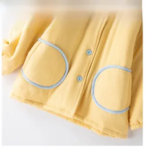 Détail de l'ourlet coupe-vent et de la texture polaire sur ce vêtement enfant jaune