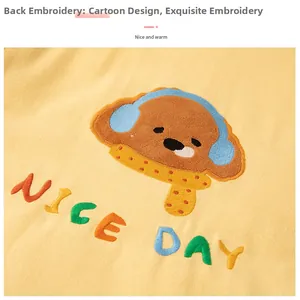 Détail de la broderie chien mignon et lettrage NICE DAY sur la veste matelassée jaune hiver