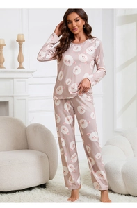 Detail of soft pink long-sleeved pajama set featuring white cartoon sheep prints on fabric