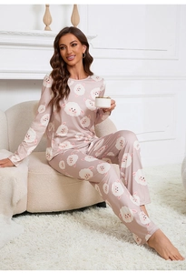 Detail of cute lamb print on long-sleeved silk pajamas set with soft pink fabric texture