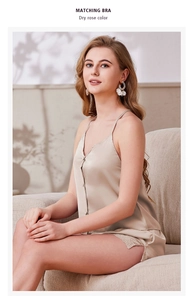 Détail d'un pyjama en satin de soie avec dentelle et boutons en couleur rose sec