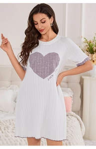 Detail of white ribbed fabric pajamas with purple heart print and ruffled lettuce hem edge