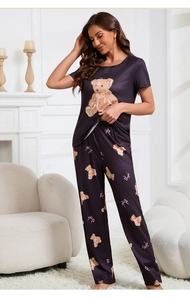 Close-up of cute teddy bear and pink bow print on soft navy blue pajama set for women