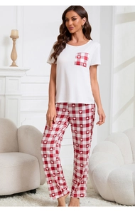 Dettaglio dei pantaloni da casa a quadretti rossi con cuori bianchi e dettaglio tasca