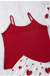 Détail du caraco côtelé rouge et du pantalon de pyjama blanc à motifs cœurs rouges