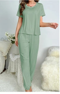 Detail of sage green milk silk pajama set showing soft texture and draped fit on model