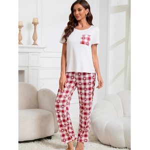 Set loungewear donna con t-shirt bianca e pantaloni a quadretti rossi in casa