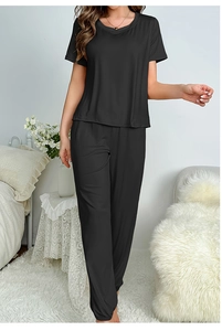 Detail view of black short sleeve loungewear set with joggers in a bedroom setting