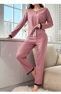 Detail of dusty pink rib-knit pajamas with elegant black lace trim and waist tie