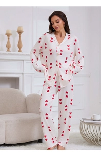 Close-up of cream waffle knit pajamas with red hearts and pearl buttons detail