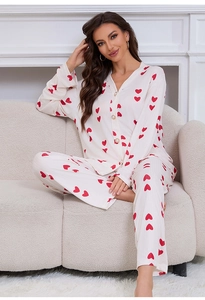 Detail shot of white ribbed heart print pajama set with pearl buttons on soft sofa