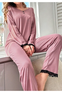 Detailed view of the delicate black lace trim on pink ribbed long-sleeved pajama set cuffs