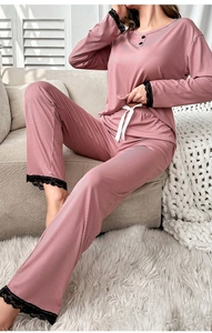 Detailed close-up of pink ribbed pajama set featuring black lace trim and silk drawstring