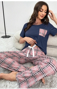 Détail du haut de pyjama en coton bleu marine avec poche à carreaux roses et nœud