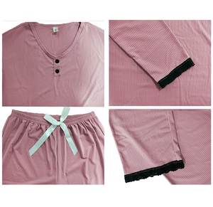 Detailed close-up of ribbed mauve pajama set with black lace trim and green ribbon bow