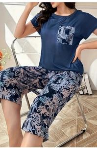 Dettaglio del pigiama blu navy con pantaloni capri floreali e maglia a maniche corte con tasca