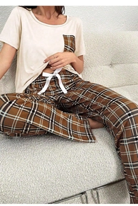 Détail du pantalon de pyjama en coton à carreaux avec un nœud décoratif en ruban