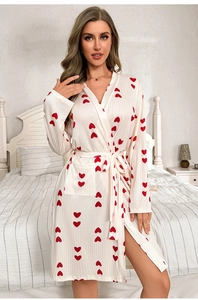 Detail of soft ribbed cream robe featuring red heart patterns and a waist tie closure