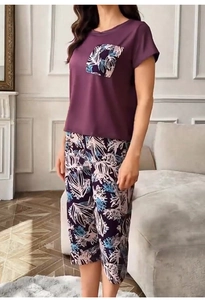 Dettaglio del top del pigiama viola con tasca a foglie e pantaloni a fiori per donna