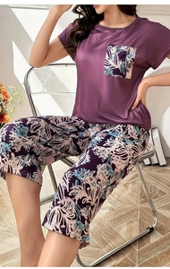 Dettaglio di un set pigiama viola a maniche corte con pantaloni capri floreali da donna