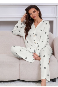 Close-up of white pajama set with heart print, V-neck, buttons and ribbed fabric texture