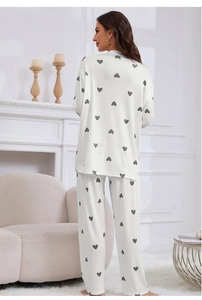 Rear view of white rib-knit pajama set with gray heart prints in a cozy room setting