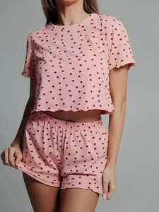Detail of light pink pajama set with red heart prints and delicate ruffle trim edges