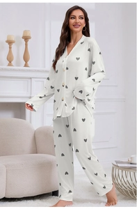 Detail of soft jacquard pajamas showing pearl buttons and grey heart print on white fabric