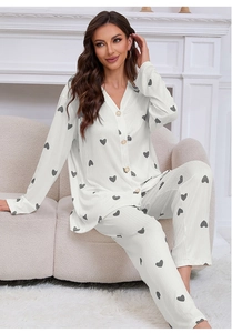 Detail of cream long-sleeved pajama set with grey heart print and pearl buttons