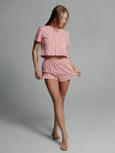Close-up of pink pajamas set with heart print, featuring ruffles on sleeves and shorts