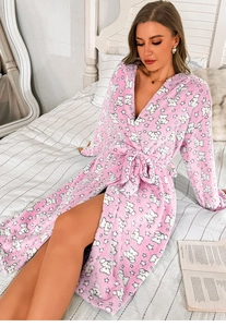 Detail of pink flannel bathrobe featuring white cartoon bear patterns and soft fleece texture