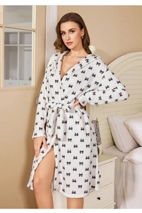 Détail du peignoir en peluche blanc avec motifs nœuds noirs et polaire douce