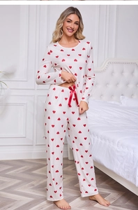 Detail of soft pajama set featuring red heart prints and a decorative satin bow on waistband