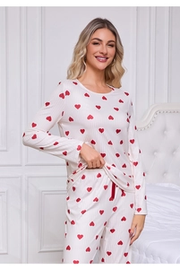 Detail shot of white ribbed knit pajama set featuring vibrant red heart patterns