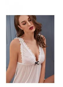 Détail de la dentelle florale et du nœud noir sur une nuisette en maille blanche