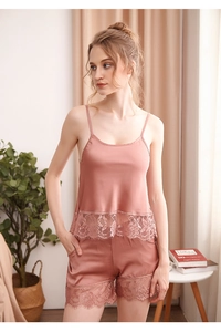 Détail d'un ensemble pyjama en satin avec dentelle délicate sur le caraco et le short