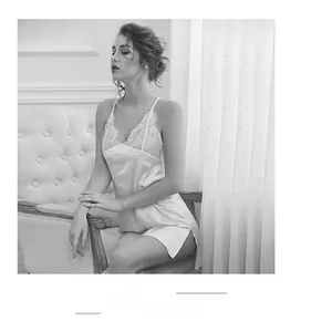 Vue détaillée d'une nuisette en satin blanc avec dentelle florale et fente latérale
